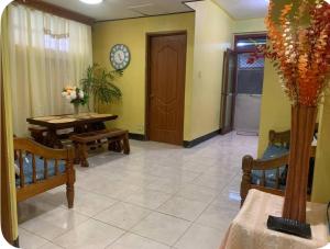 a living room with benches and a table and a clock at GSB City Apartelle in Tuguegarao City