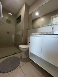 a bathroom with a toilet and a shower and a sink at Apart Canoa Quebrada vista mar- condominio fechado in Aracati