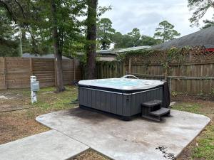 vasca idromassaggio in cortile accanto a una recinzione di Gilded Magnolia Hideout, Sleeps8, Hot Tub, pet friendly a Savannah