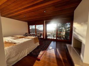 a bedroom with two beds and a large window at Hortênsia Boutique - Suites Privativas em Chalés de Luxo in Campos do Jordão +120 photos