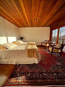 a bedroom with a large bed and a rug at Hortênsia Boutique - Suites Privativas em Chalés de Luxo in Campos do Jordão