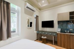 une chambre avec un lit et une cuisine avec une télévision dans l'établissement Brassbell l Zamalek l Daoud Studios Villa D, au Caire