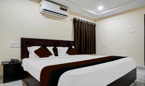 a bedroom with a large bed and a air conditioner at Hotel CJ Pride in Vijayawāda