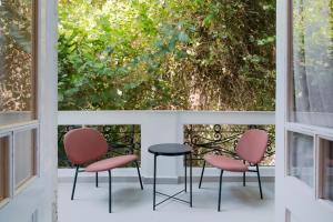 trois chaises et une table devant une fenêtre dans l'établissement Brassbell l Zamalek l Daoud Studios Villa D, au Caire
