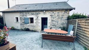 a patio with a table and chairs and a building at Gîte La Loge in Corné