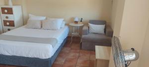 a small bedroom with a bed and a chair at Casa Del Sol La Herradura in La Herradura