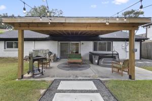 un patio con pergolato in legno e griglia di Charming 3-bedroom house in terrific Houston with AC, WiFi a Houston