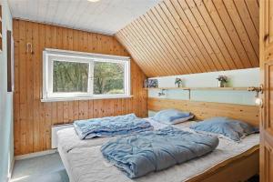 Ce lit se trouve dans un dortoir doté de murs en bois et d'une fenêtre. dans l'établissement 0142-Romo-Ivigtut-1, à Kongsmark