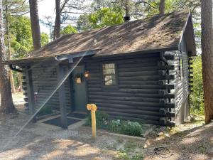 a log cabin with a sign in front of it at Authentic Log Cabin with Full Kitchen, Fireplace a in Eureka Springs