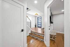 a hallway with white walls and a staircase with a chair at Monastery Guest House 2BR Option in Cincinnati +20 photos