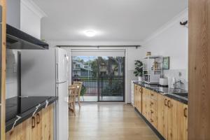 a kitchen with a refrigerator and a counter top at Lakefront Peace and Relaxation in Budgewoi +24 photos