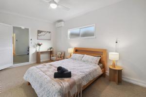 a bedroom with a bed with a black hat on it at Waterside Whispers in Gorokan