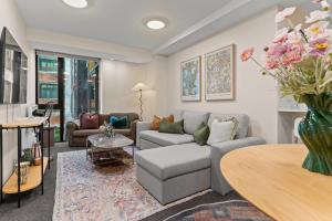 オークランドにあるGorgeous Abode With Pool and Parking near SkyTowerのソファとテーブルのあるリビングルーム