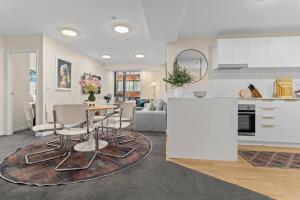 オークランドにあるGorgeous Abode With Pool and Parking near SkyTowerのテーブルと椅子のあるキッチンとリビングルーム