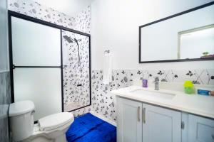 a bathroom with a toilet and a sink and a mirror at Spacious Runaway Bay Home Near Beach and Dining in Runaway Bay