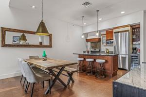 a kitchen with a wooden table and some chairs at Amazing mountain Views 3BR Penthouse with private Balconies in Canmore