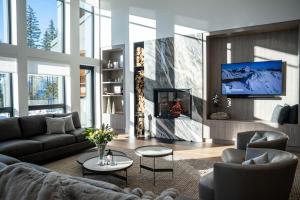 a living room with a couch and a tv at Sitka Spruce Mountain Chalet in Revelstoke