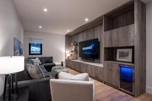 a living room with a couch and a tv at Sitka Spruce Mountain Chalet in Revelstoke