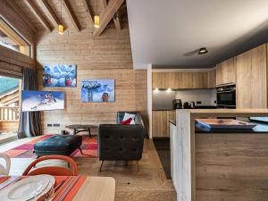 a kitchen and living room with wooden walls at Duplex de Charme à Courchevel Moriond, à Proximité des Pistes et Commodités - FR-1-563-57 in Courchevel