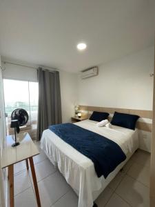 a bedroom with a large bed and a window at Apart Canoa Quebrada vista mar- condominio fechado in Aracati