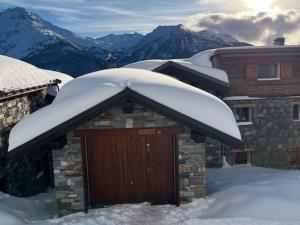 eine Garage mit Schnee auf dem Dach eines Hauses in der Unterkunft Appartement Chalet Spacieux 6 Pièces, Wi-Fi, Vue Panoramique - FR-1-275-148 in Montvalezan