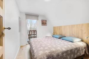 a bedroom with a large bed with blue pillows at 0236-Romo-Havnebyvej-61-G in Kongsmark