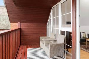 a patio with two chairs on a wooden deck at 0236-Romo-Havnebyvej-61-G in Kongsmark