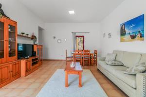 a living room with a couch and a table at Pool Retreat Tamaragua in La Oliva