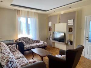 a living room with two couches and a tv at Apartman Buki in Bjeliši