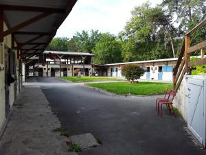 Una calle vacía con una silla roja frente a un edificio. en Gîte du rocher d'argout, en Noisy-sur-École
