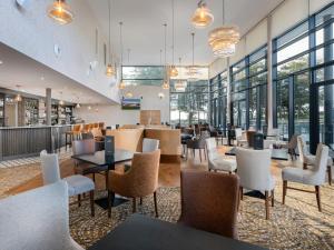 a restaurant with tables and chairs and windows at Ravenport Resort in Wexford
