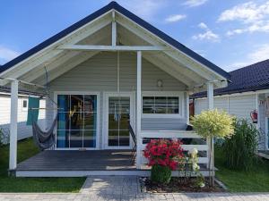 a house with a porch and a porch swing at Domki Martes Wicie in Wicie