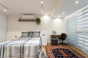 un dormitorio con una cama y un escritorio en Apartamento em Itaipava com Piscina e Academia, en Itaipava