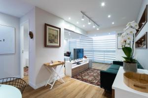 Una sala de estar con un sofá y un escritorio. en Apartamento em Itaipava com Piscina e Academia, en Itaipava