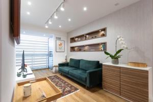 Una sala de estar con un sofá verde y una mesa. en Apartamento em Itaipava com Piscina e Academia, en Itaipava 26 fotos más