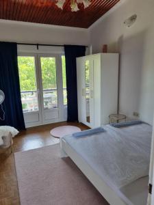 Un dormitorio con una cama grande con cortinas azules. en Simay Apartman II, en Balatonalmádi