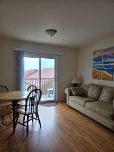 a living room with a table and a couch at Hunts Point Rustic Coastal Retreat with King Bed in Summerville Centre