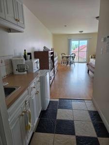 a kitchen with white cabinets and a living room at Hunts Point Rustic Coastal Retreat with King Bed in Summerville Centre