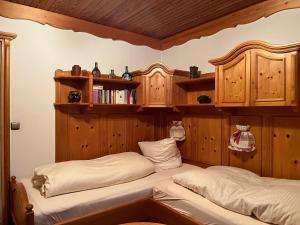 two beds in a room with wooden walls and shelves at Ferienwohnung Schanzenblick in Oberstdorf