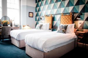 a hotel room with two beds in a room at The Queen's Head in Kingston upon Thames