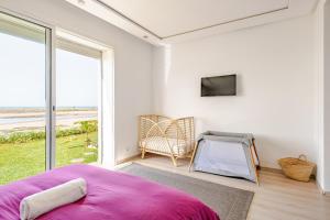 a bedroom with a pink bed and a large window at La Villa des Rochers in Temara