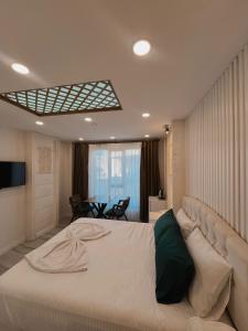 a bedroom with a large white bed with a couch at Midyat Amaara Konağı Otel&Cafe in Midyat