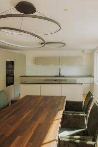 a kitchen with a wooden table and a large chandelier at Brück Residenz in Regensburg