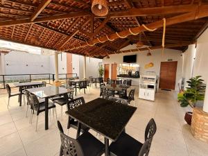 a restaurant with tables and chairs and a kitchen at Village Comfort Hotel in Canindé de São Francisco