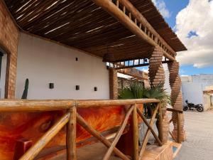 a building with a wooden porch with a wooden roof at Village Comfort Hotel in Canindé de São Francisco