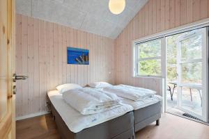 a bedroom with a bed with white sheets and a window at 0257-Romo-Chresten-Krommes-Vej-9 in Tagholm