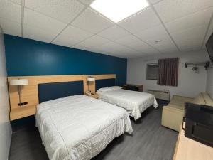 a bedroom with two beds and a blue wall at Anchor inn in New Johnsonville