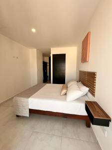 カンクンにあるDepartamento con Vistas y Albercaの木製のヘッドボードが付いた大きなベッドのある寝室
