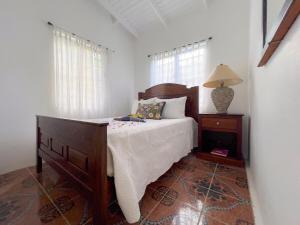 a bedroom with a bed and a table with a lamp at Tropical Retreat in Matthews