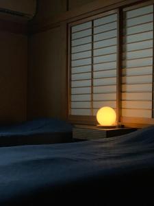 a bedroom with two beds and a lamp next to a window at Sado - House - Vacation STAY 20051 in Sado
